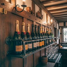 Load image into Gallery viewer, Industrial steel wine shelf with a front rail displaying champagne bottles on a wooden wall