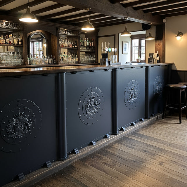 Matt black bar front panels with cast iron lion plaques, rivets and rounded posts in a traditional pub